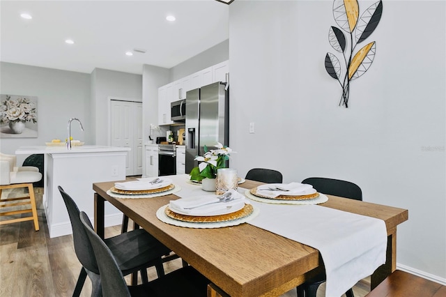 dining space with dark hardwood / wood-style flooring and sink