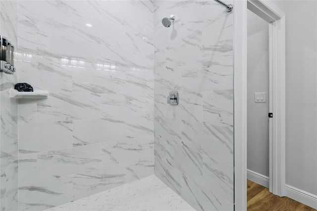 bathroom featuring wood-type flooring and tiled shower