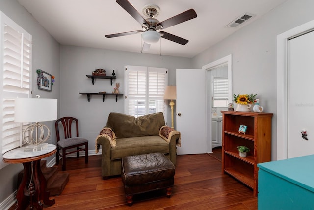 living area with ceiling fan, plenty of natural light, and dark hardwood / wood-style floors