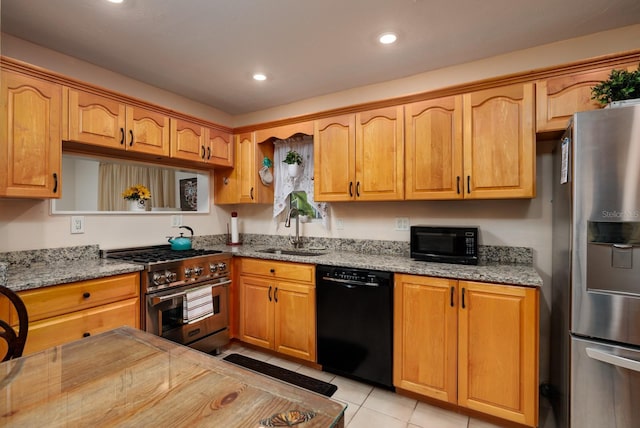 kitchen featuring light stone countertops, light tile patterned floors, sink, and black appliances