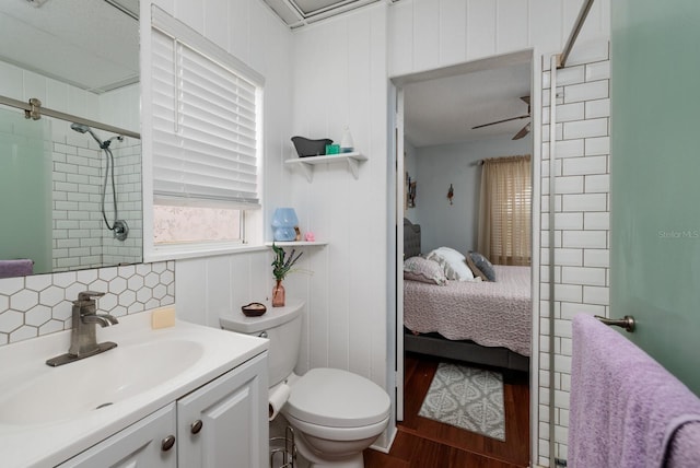 bathroom featuring hardwood / wood-style floors, vanity, ceiling fan, toilet, and an enclosed shower