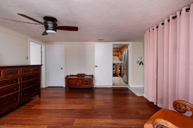 interior space with ceiling fan, wood-type flooring, and a textured ceiling