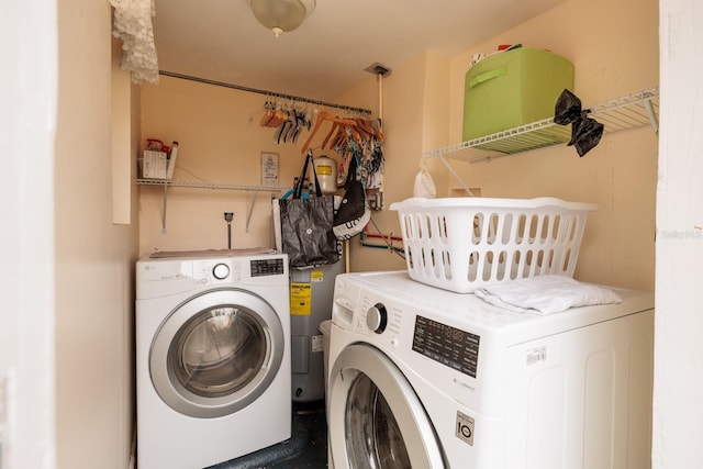 laundry room featuring electric water heater and independent washer and dryer