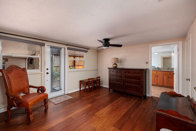 living area with ceiling fan and dark hardwood / wood-style flooring