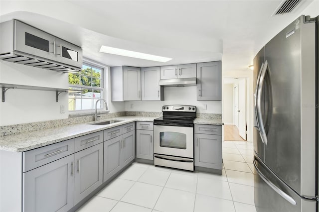 kitchen featuring light stone countertops, stainless steel fridge, sink, electric stove, and gray cabinets