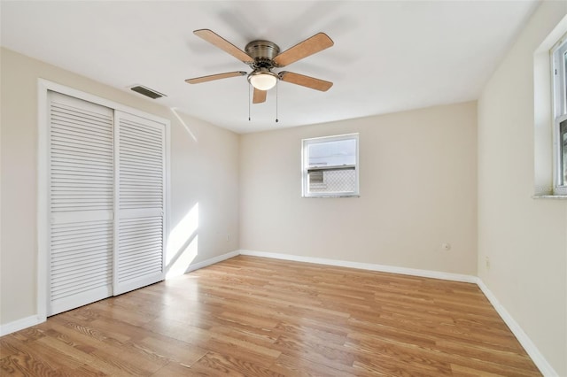 unfurnished bedroom with ceiling fan, a closet, and light hardwood / wood-style flooring