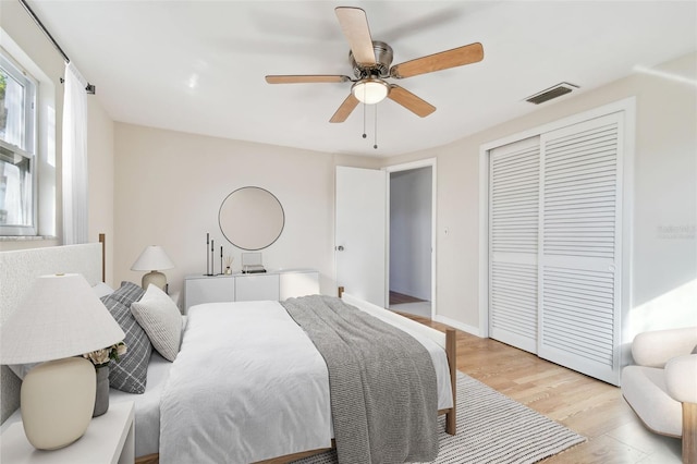 bedroom with light wood-type flooring, a closet, and ceiling fan