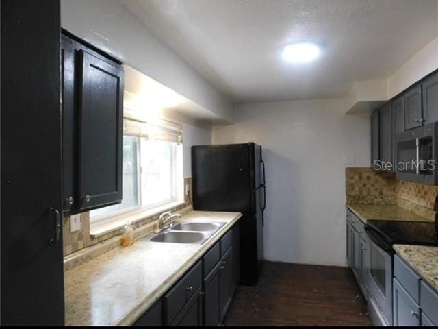 kitchen featuring dark hardwood / wood-style flooring, stainless steel appliances, tasteful backsplash, and sink