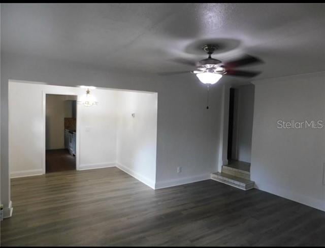 unfurnished room with dark wood-type flooring and ceiling fan