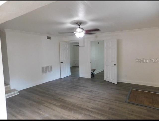 empty room with dark hardwood / wood-style flooring and ceiling fan