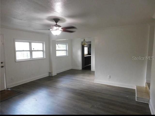 spare room featuring ceiling fan and dark wood-type flooring