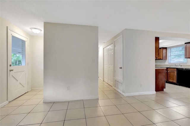 interior space featuring plenty of natural light, light tile patterned floors, and black dishwasher