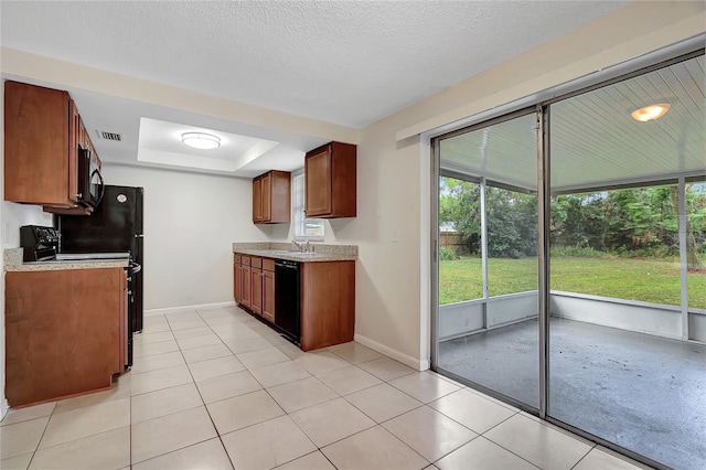 kitchen featuring a textured ceiling, a raised ceiling, sink, black appliances, and light tile patterned floors