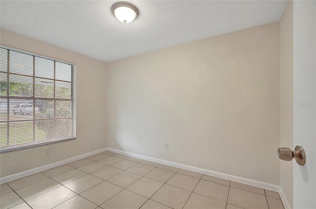 tiled spare room with a textured ceiling