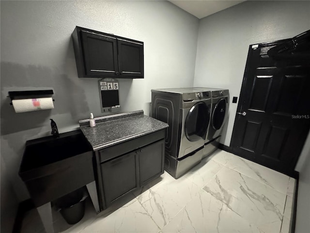 clothes washing area with cabinets and independent washer and dryer