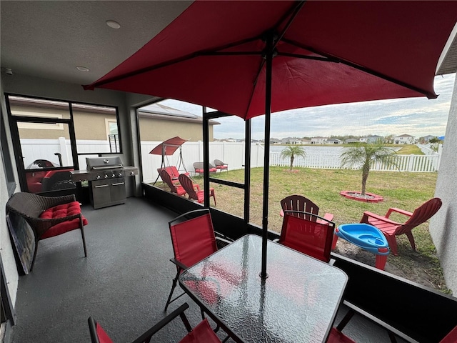 sunroom featuring lofted ceiling and a water view