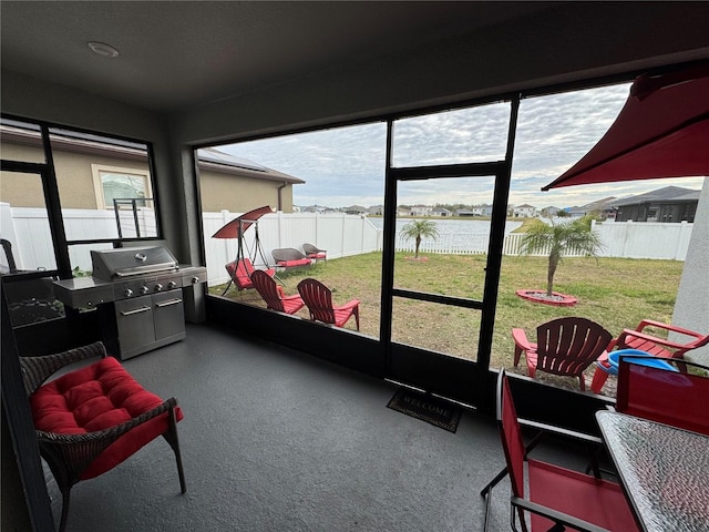 sunroom / solarium featuring a wealth of natural light and a water view