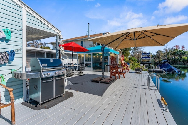 deck featuring a water view, a dock, and area for grilling