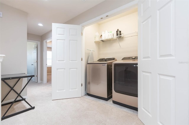 washroom with washing machine and dryer and light carpet