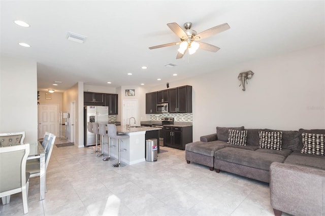 living room featuring ceiling fan and sink