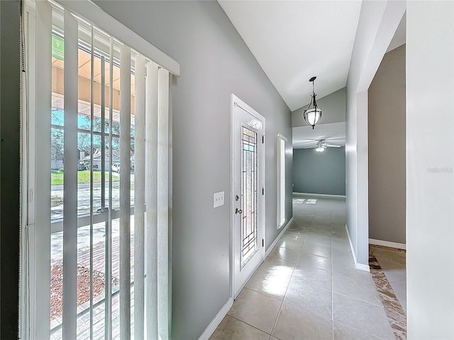 interior space with a wealth of natural light, light tile patterned floors, vaulted ceiling, and ceiling fan