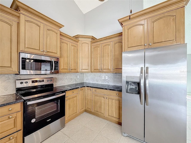 kitchen featuring light brown cabinets, dark stone countertops, appliances with stainless steel finishes, tasteful backsplash, and light tile patterned flooring