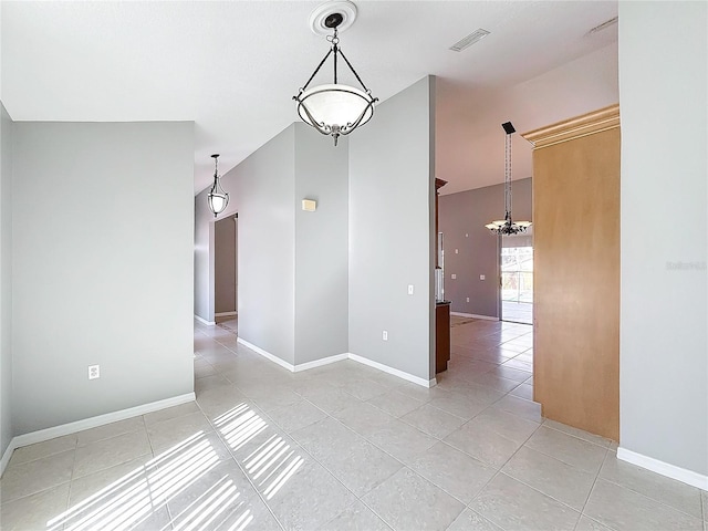 unfurnished room featuring a notable chandelier and light tile patterned flooring