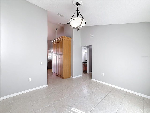 spare room with light tile patterned floors and high vaulted ceiling