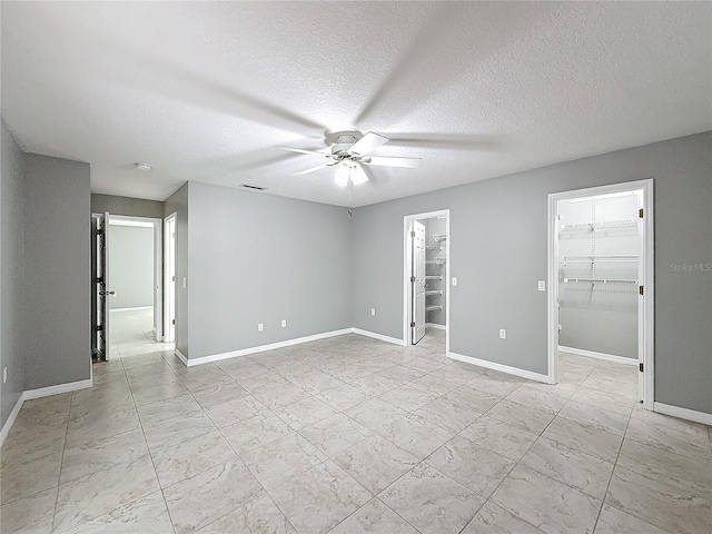 empty room featuring a textured ceiling and ceiling fan