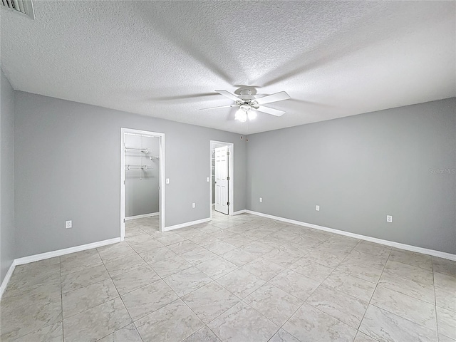 unfurnished bedroom featuring ceiling fan, a walk in closet, a textured ceiling, and a closet