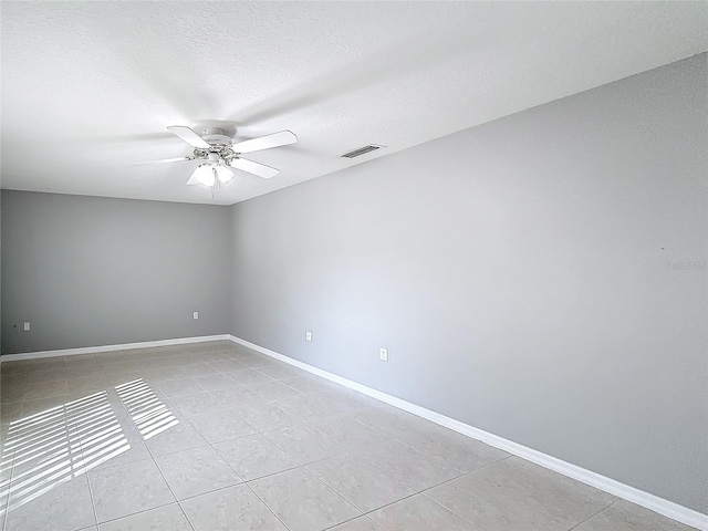 tiled spare room with a textured ceiling and ceiling fan