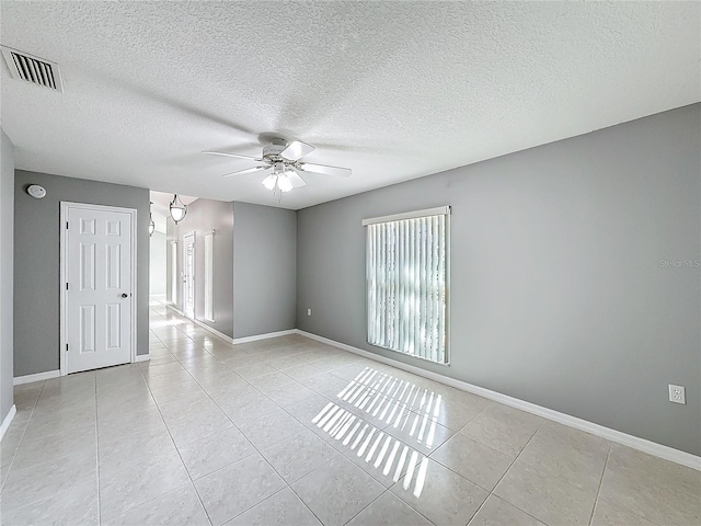 unfurnished room with light tile patterned floors, a textured ceiling, and ceiling fan