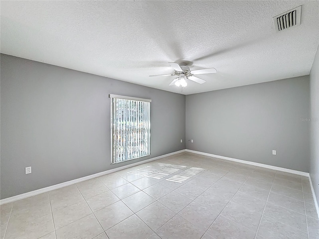 tiled empty room featuring ceiling fan and a textured ceiling