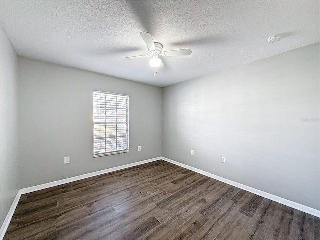 spare room with dark hardwood / wood-style floors, ceiling fan, and a textured ceiling