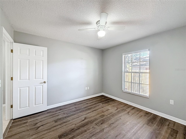 unfurnished room featuring a textured ceiling, dark hardwood / wood-style floors, and ceiling fan