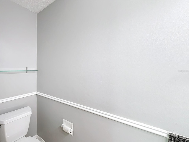 bathroom featuring a textured ceiling and toilet