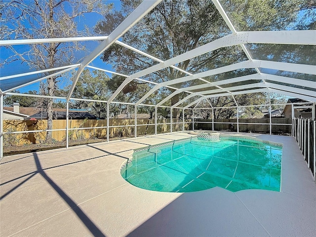 view of pool with glass enclosure and a patio