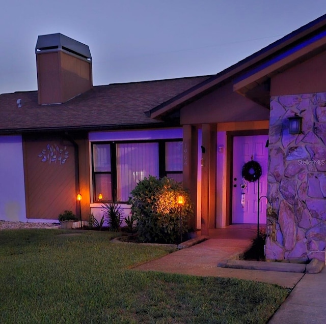 exterior entry at dusk with a lawn