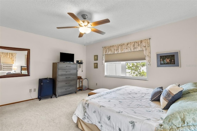 carpeted bedroom featuring ceiling fan and a textured ceiling