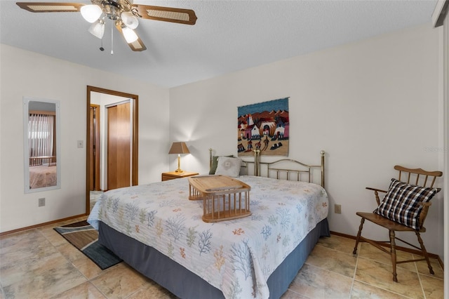 bedroom featuring ceiling fan and a textured ceiling