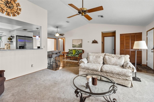 living room with ceiling fan, lofted ceiling, and dark carpet