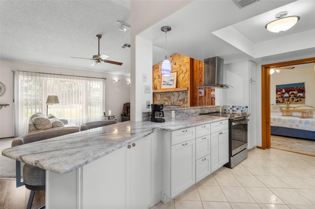 kitchen with electric stove, kitchen peninsula, light stone countertops, white cabinets, and ventilation hood