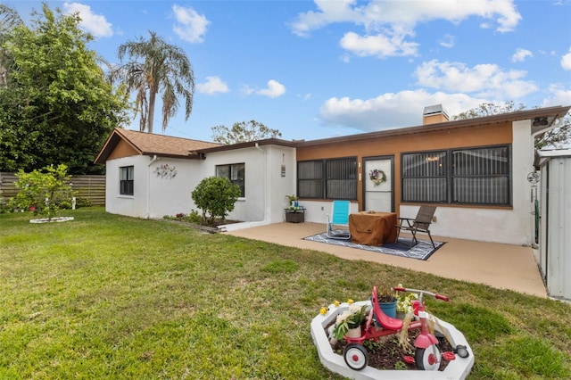 back of house with a yard and a patio