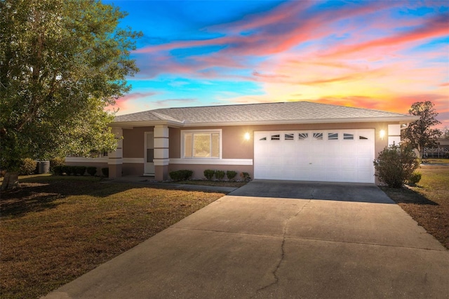 view of front facade featuring a lawn and a garage