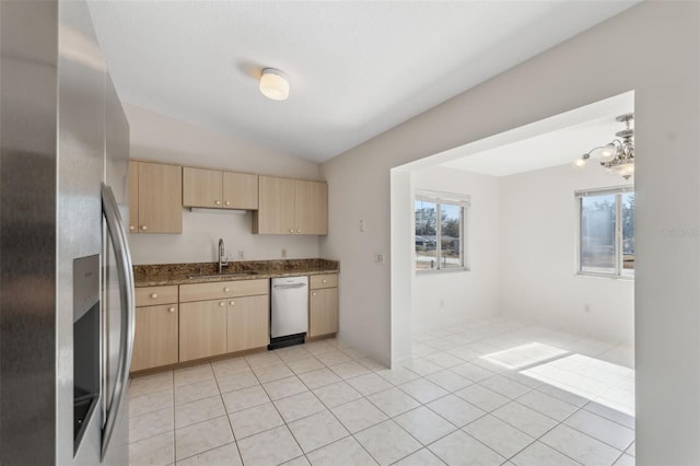 kitchen featuring vaulted ceiling, dark stone countertops, sink, stainless steel appliances, and light brown cabinetry