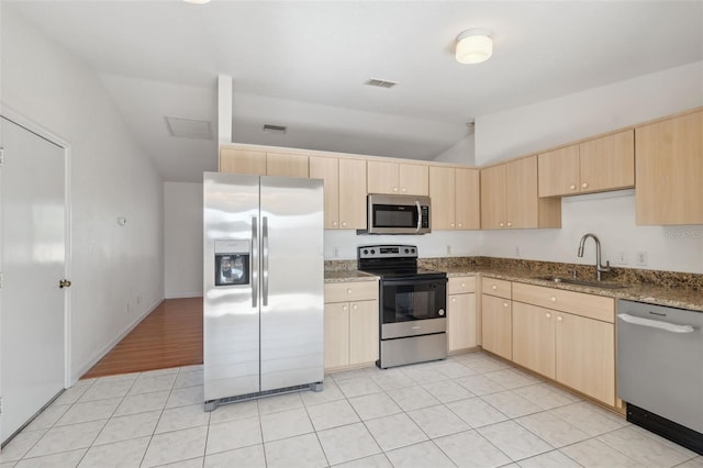 kitchen featuring appliances with stainless steel finishes, light brown cabinets, stone countertops, and sink