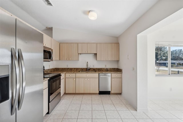 kitchen featuring light brown cabinetry, appliances with stainless steel finishes, lofted ceiling, and sink