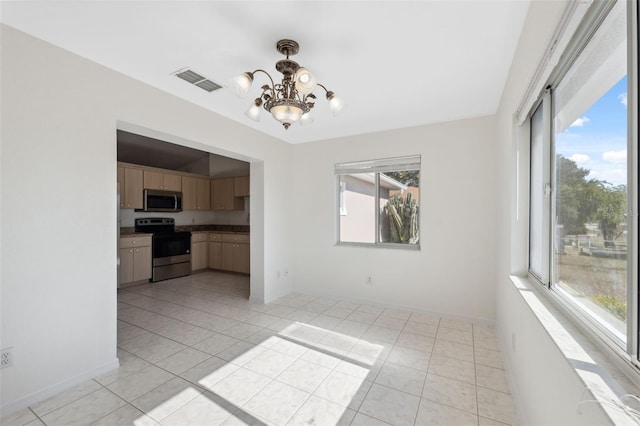 interior space featuring plenty of natural light, light tile patterned floors, and a notable chandelier