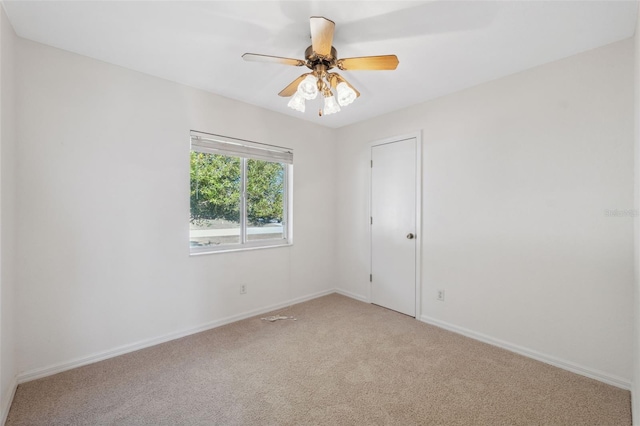 empty room featuring ceiling fan and light colored carpet