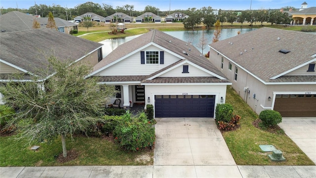 view of front of property featuring a garage and a water view